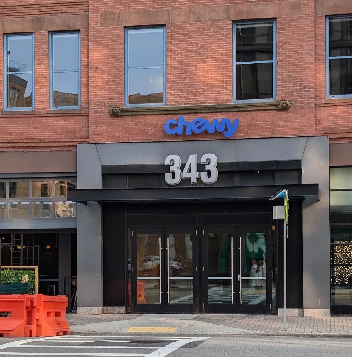 The Chewy office entrance at 343 Congress Street in Boston, with a black canopy set into a brick facade.